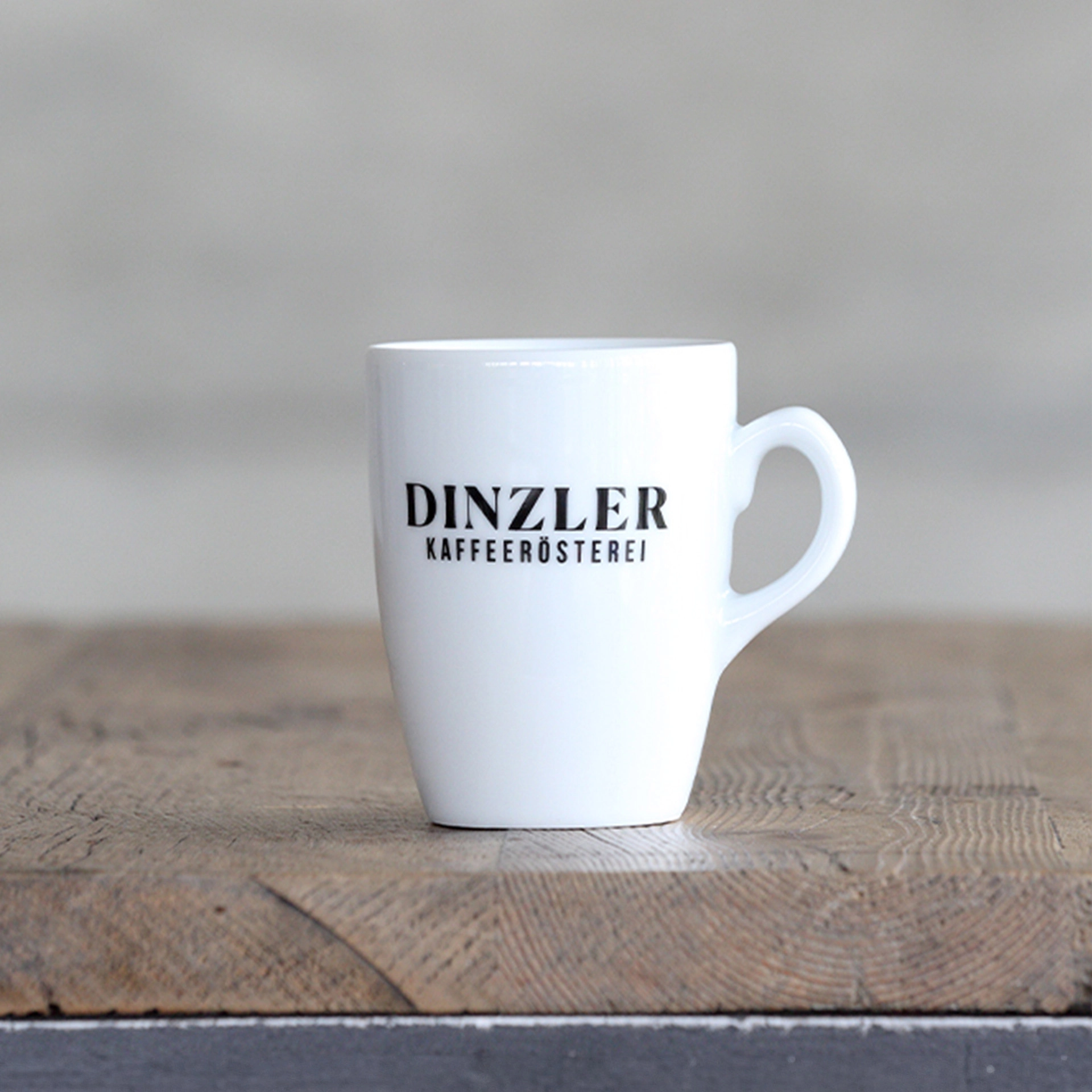 Szenebild Kaffeebecher Porzellan mit DINZLER Logo